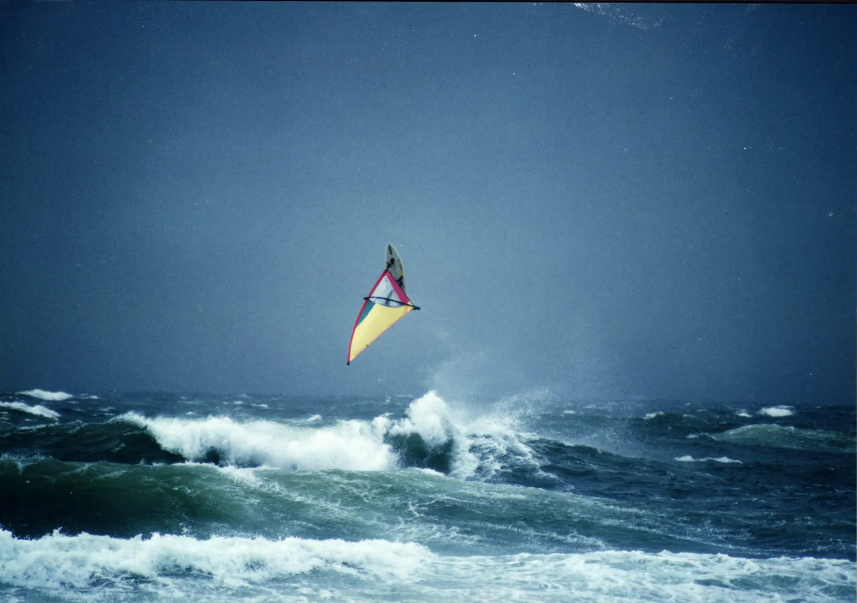 A windsurfer jumping off a wave in the surf off Sylt