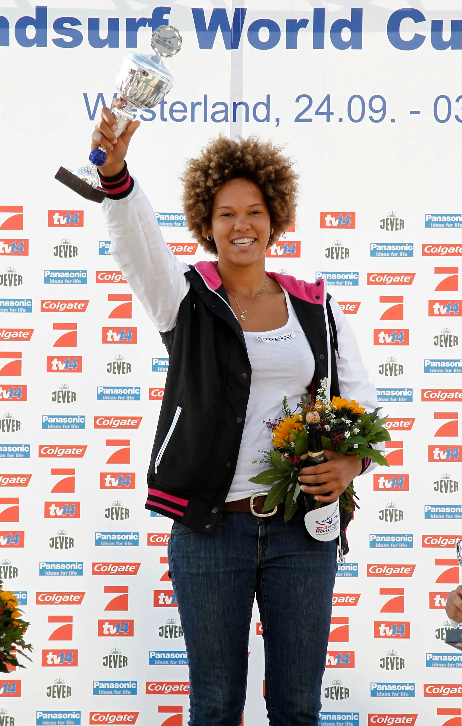 Sarah-Quita Offringa on a podium holding a trophy and flowers