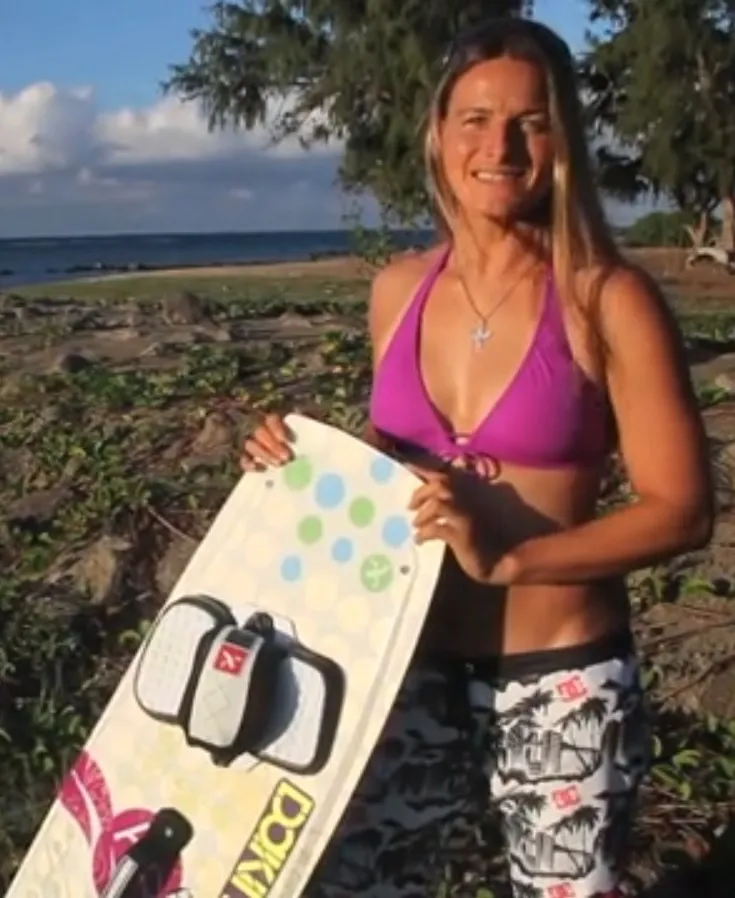 Kristin Boese holding a kiteboard on a beach