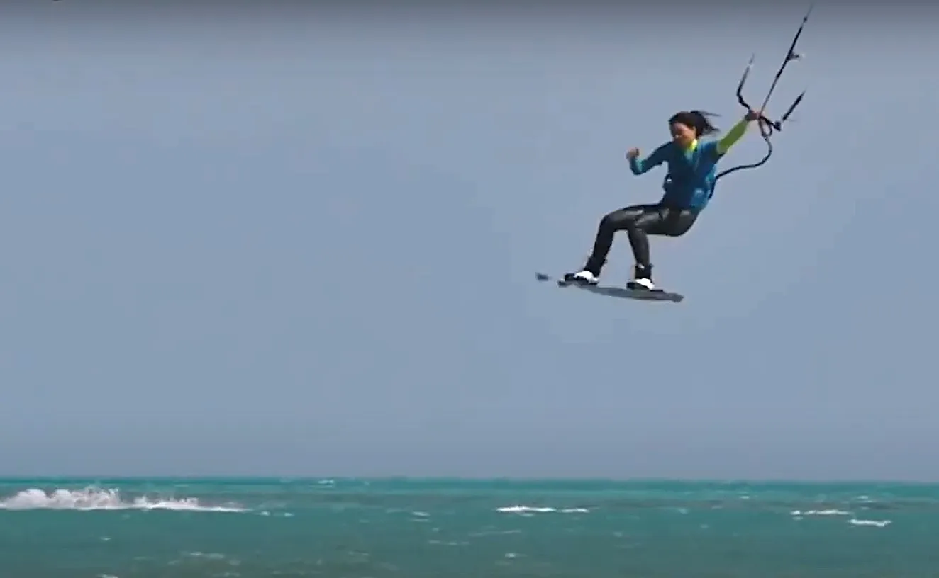 A kiteboarder in the air above the sea